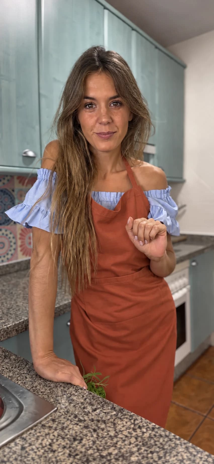 Marta en su cocina con un delantal terracota